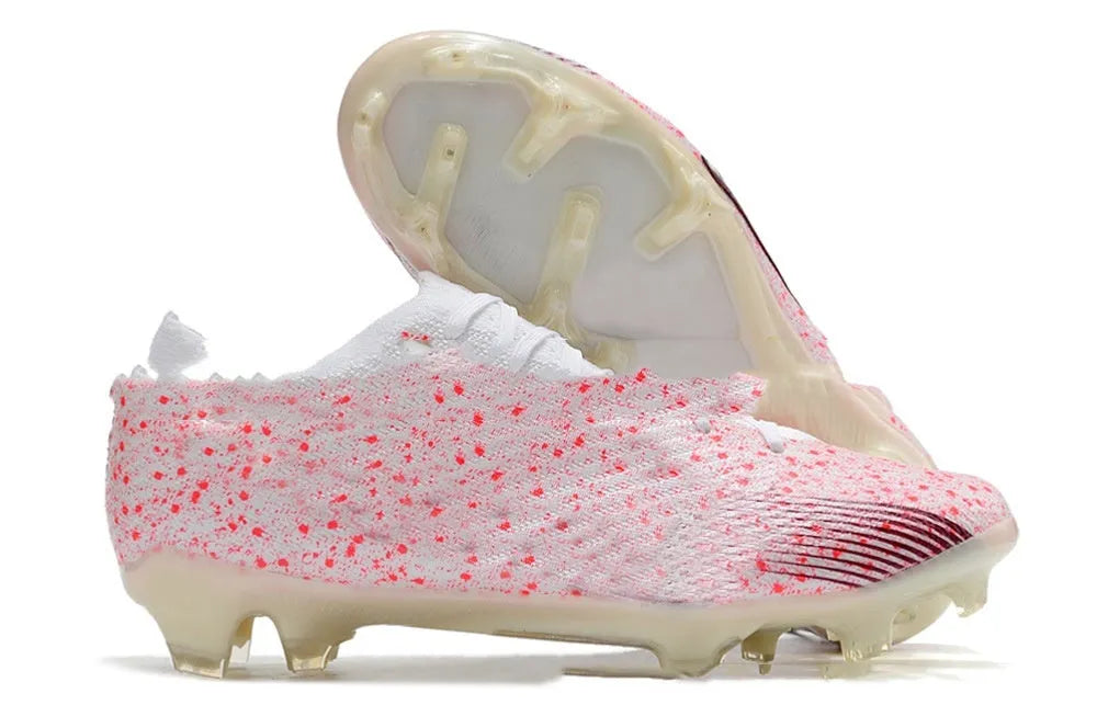 Men's black football shoes with FG studs, knitted upper, and lace-up closure on grass pitch