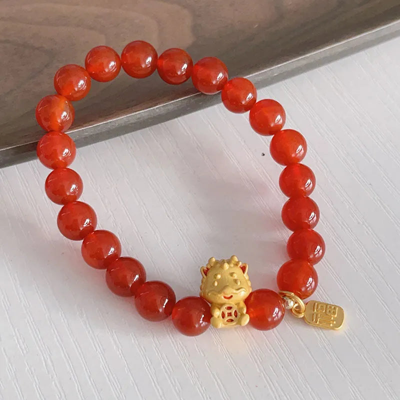 A red agate bracelet for women with Chinese style dragon and lucky bag motifs.