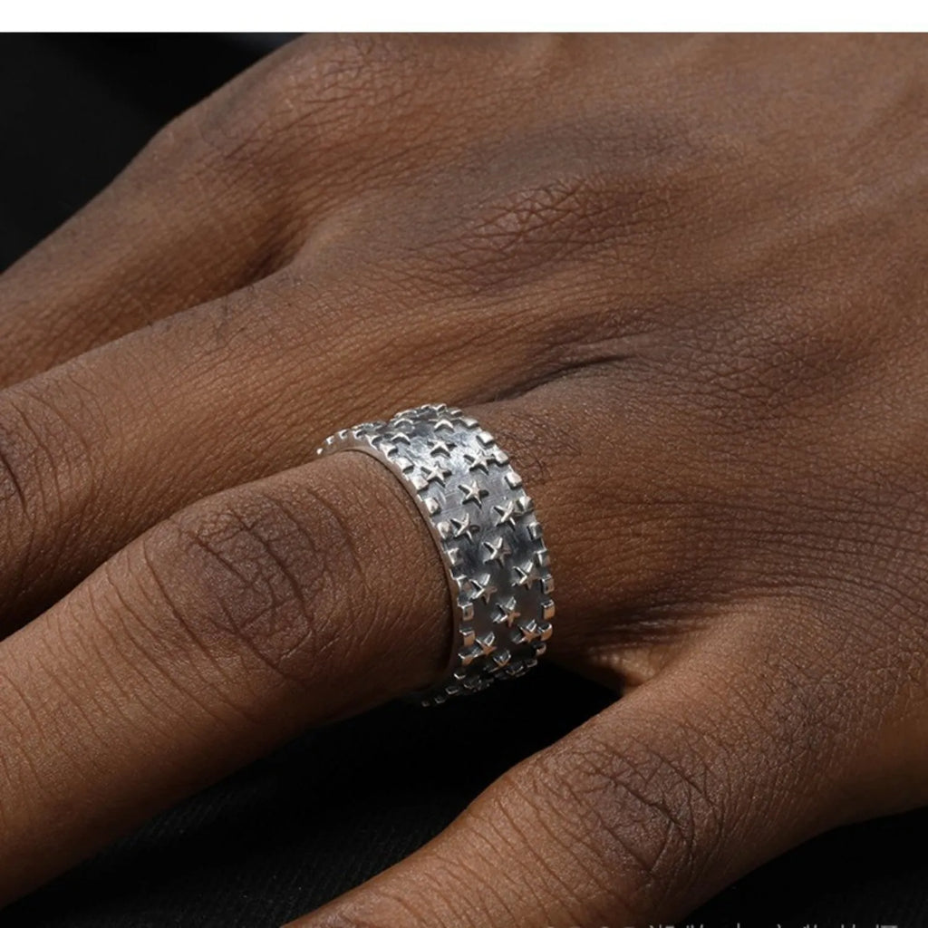Adjustable open-back sterling silver ring with a raised five-pointed star geometric pattern.