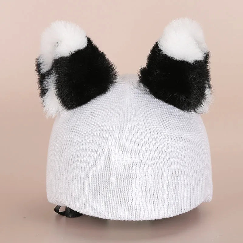 Plush fabric ski helmet decoration with cartoon design on a black ski helmet.