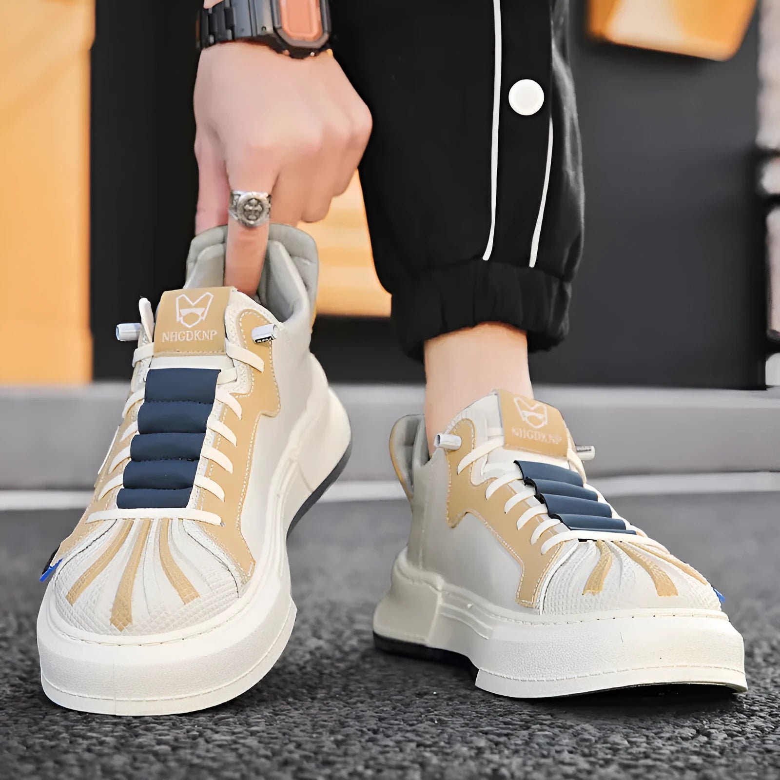 Men's beige low-top casual sneakers with elastic band and leather stitch details on microfiber upper.