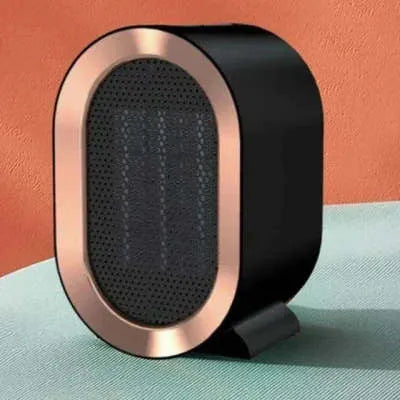 Compact black desktop electric ceramic fan heater with mechanical controls on a wooden desk