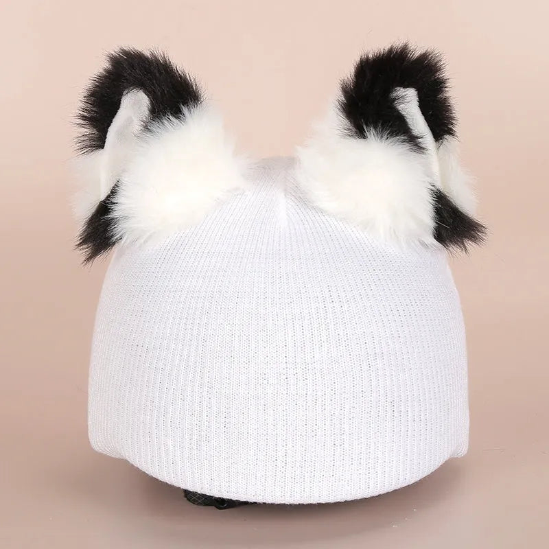 Plush fabric ski helmet decoration with cartoon design on a black ski helmet.
