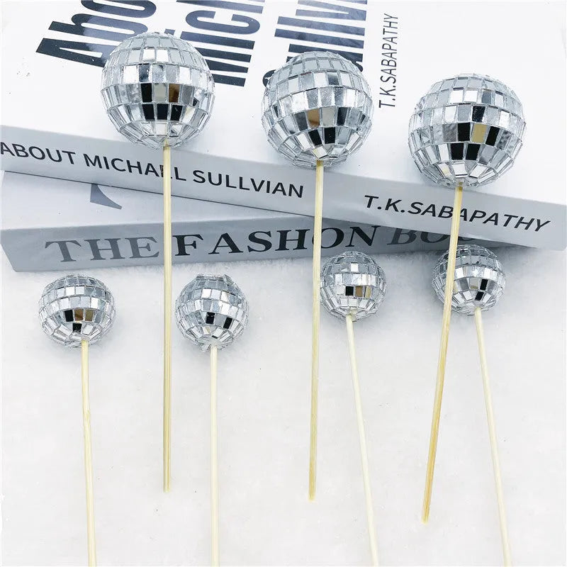 Glass disco ball cake decoration on a wooden stick, shown in different sizes for birthday cakes.