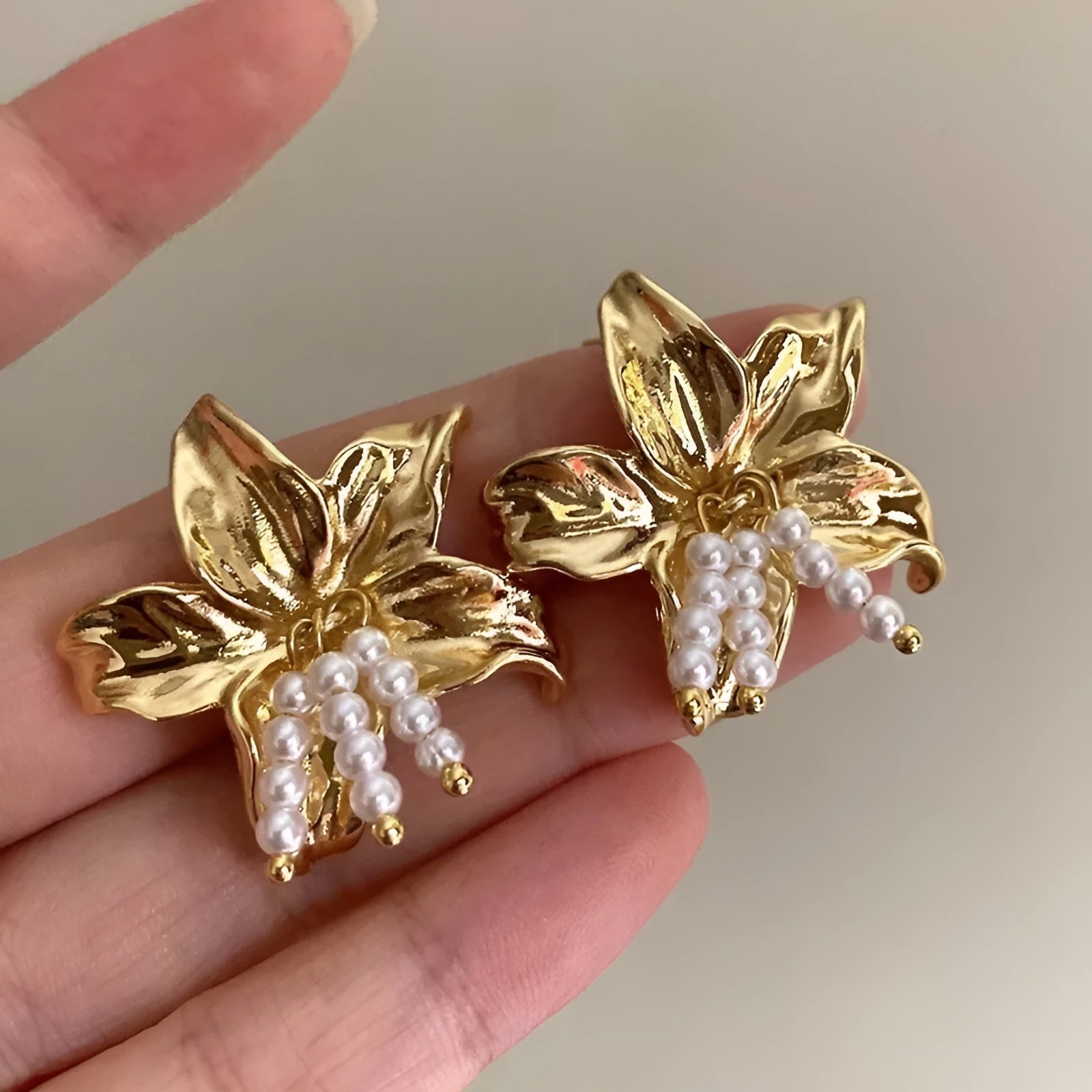 Gold H1795 metal flower earrings with pearls and an exaggerated, personalised design.