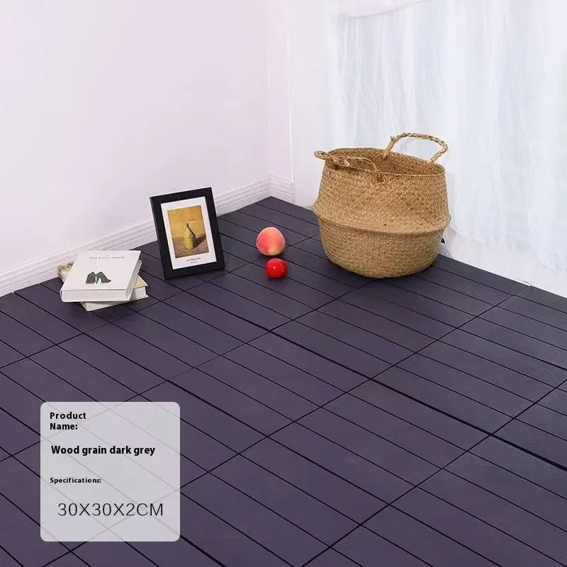 Square plastic floor tile with wood grain texture in a dark grey colour, shown on a light background.