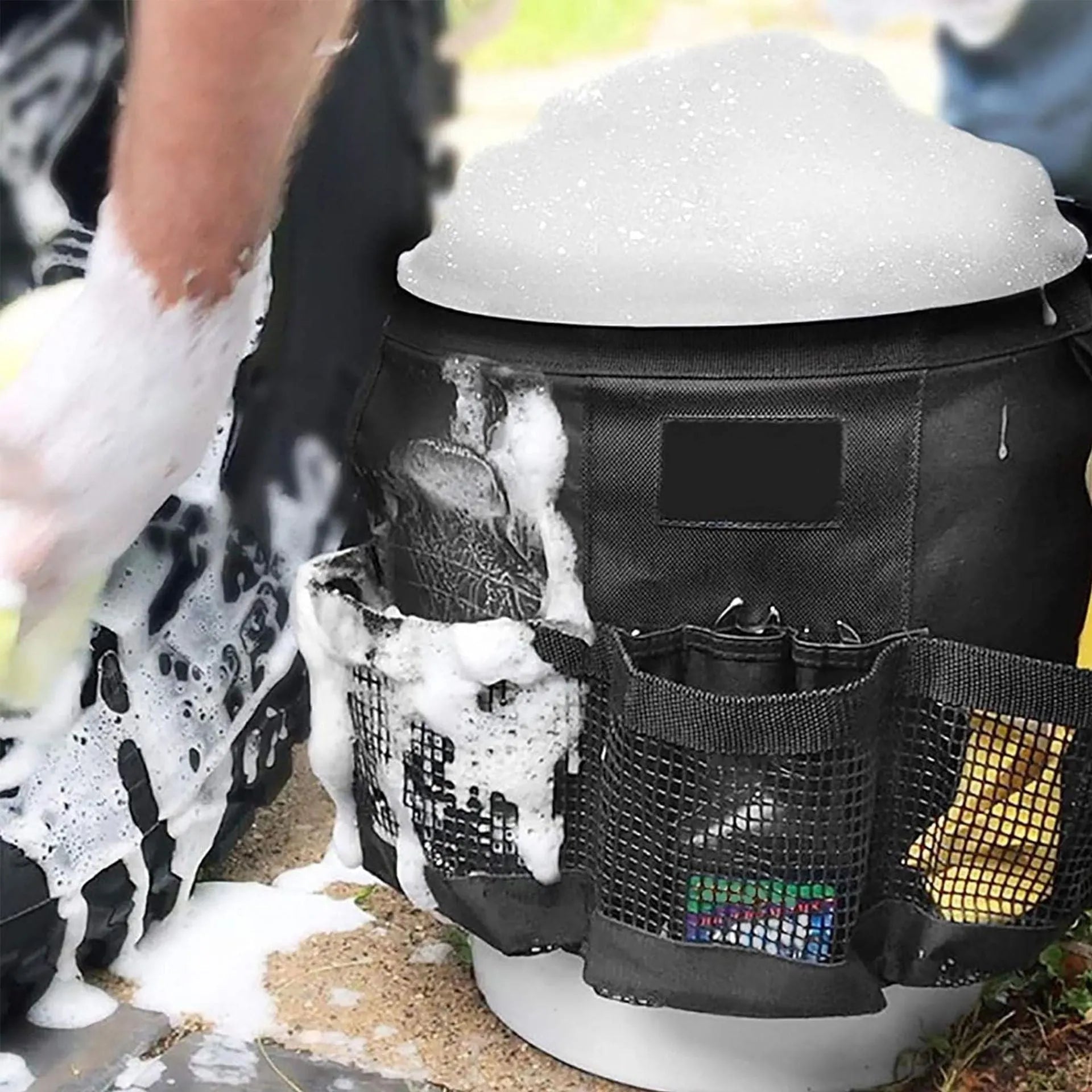 Black cylindrical polyester storage bag hanging on a 5 gallon barrel for car washing tools and outdoor gear.