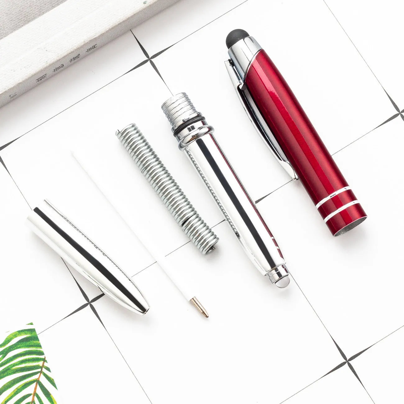 Red multifunctional metal-tipped stylus ballpoint pen with a built-in LED light.