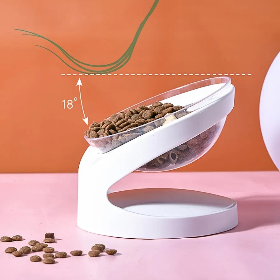 Clear plastic tilted cat food bowl on a flat surface