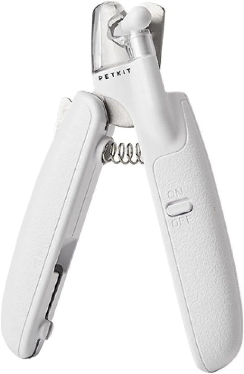 White pet nail clippers with LED light, open transparent splash guard, and separate nail file on a table