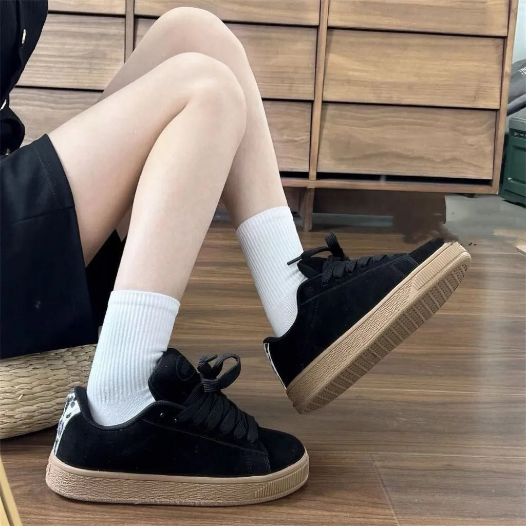 Black retro-style low-top lace-up sneakers with a round toe and waterproof platform sole.