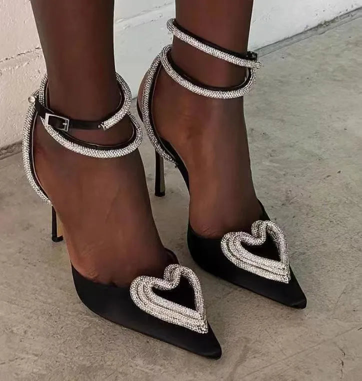 Women's pink satin sandal with heart-shaped rhinestone and cross-tape strap on a pointed toe.