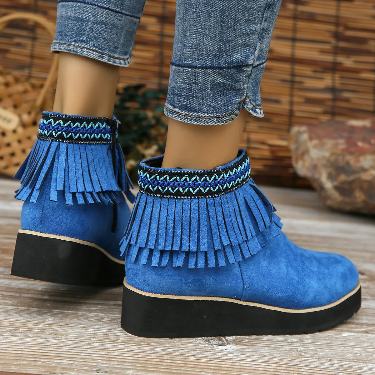 Women's dark brown suede ankle boots with a wedge heel, side zip, and decorative tassel detail.