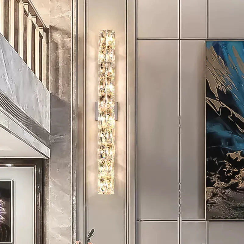 Crystal wall lamp with stainless steel frame in gold or chrome finish, mounted on a wall.