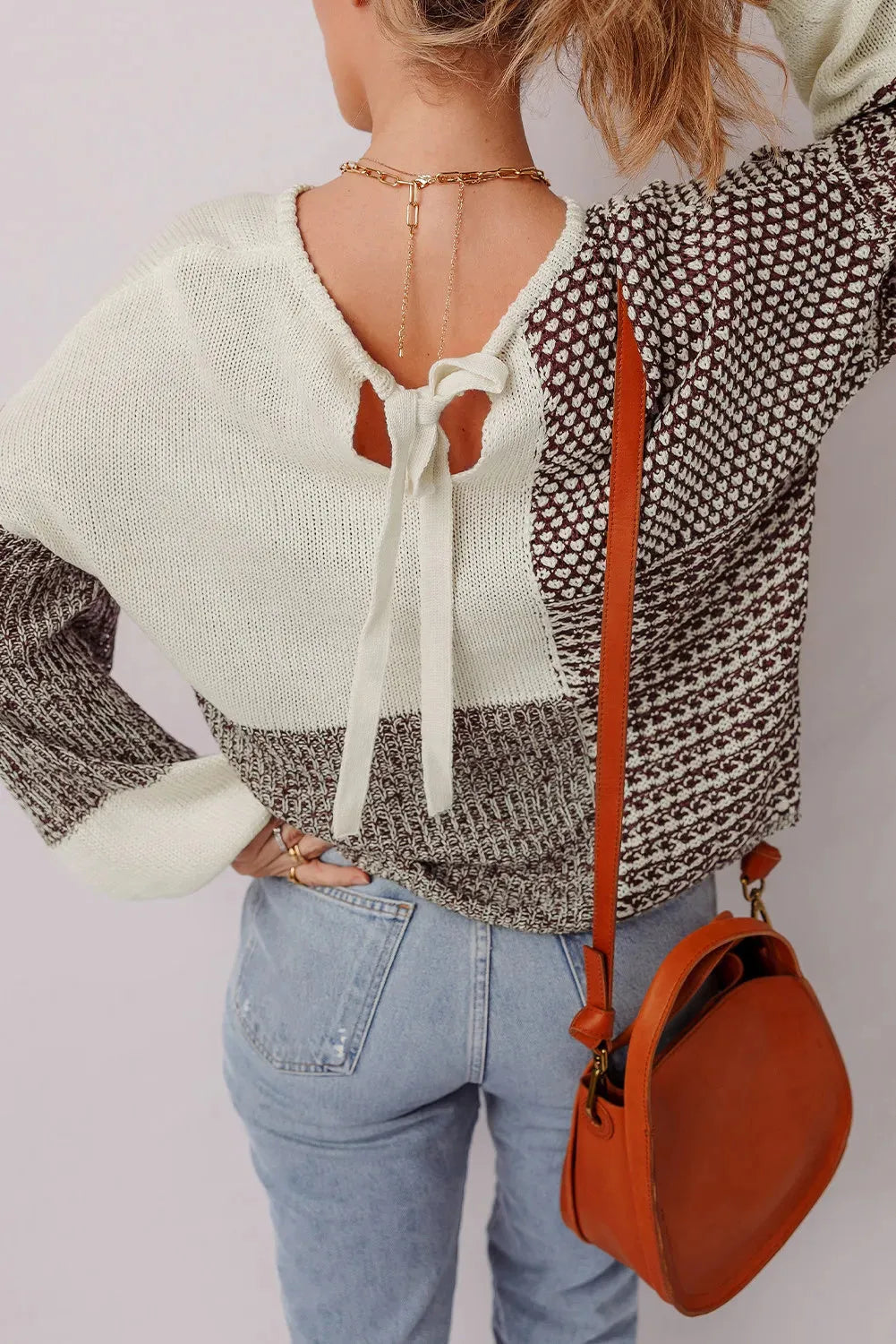 Dark khaki colour block loose sweater with back tie and drop shoulders on a hanger.