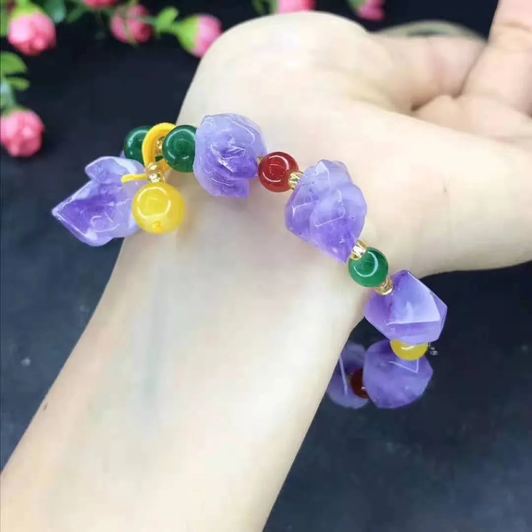 Women's amethyst bracelet with natural shaped beads and a fu character charm on an adjustable band.