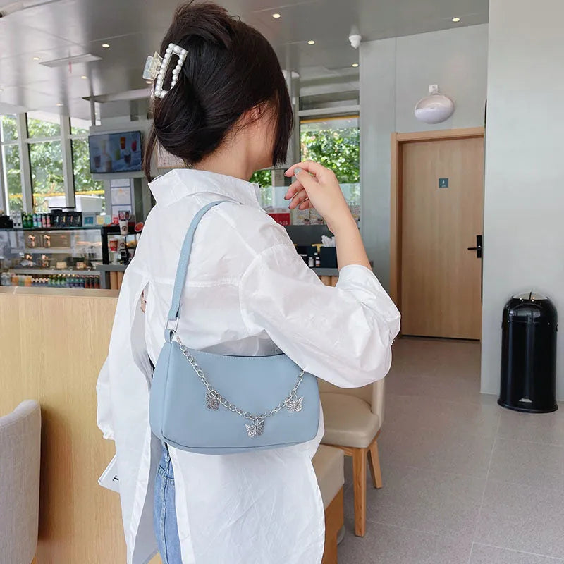 Butterfly chain crossbody bag in PU leather with a retro style, shown in light blue.