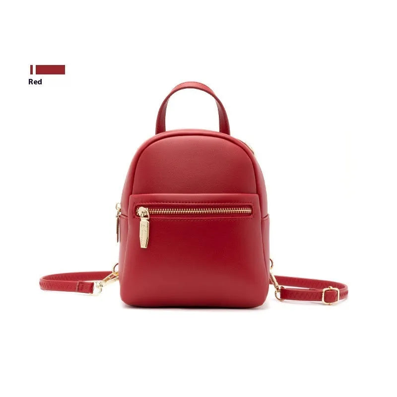 Soft black PU mini backpack with front pockets, shown open to reveal internal mobile phone sleeve and zipper compartment.