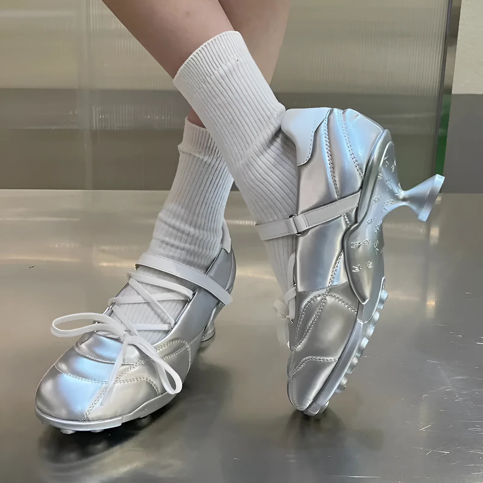 Women's silver lace-up sports shoes with a bow detail on the front, showing a low-top and round toe design.