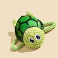 Green turtle-shaped plush dog chew toy with a knotted rope visible inside, on a white background.