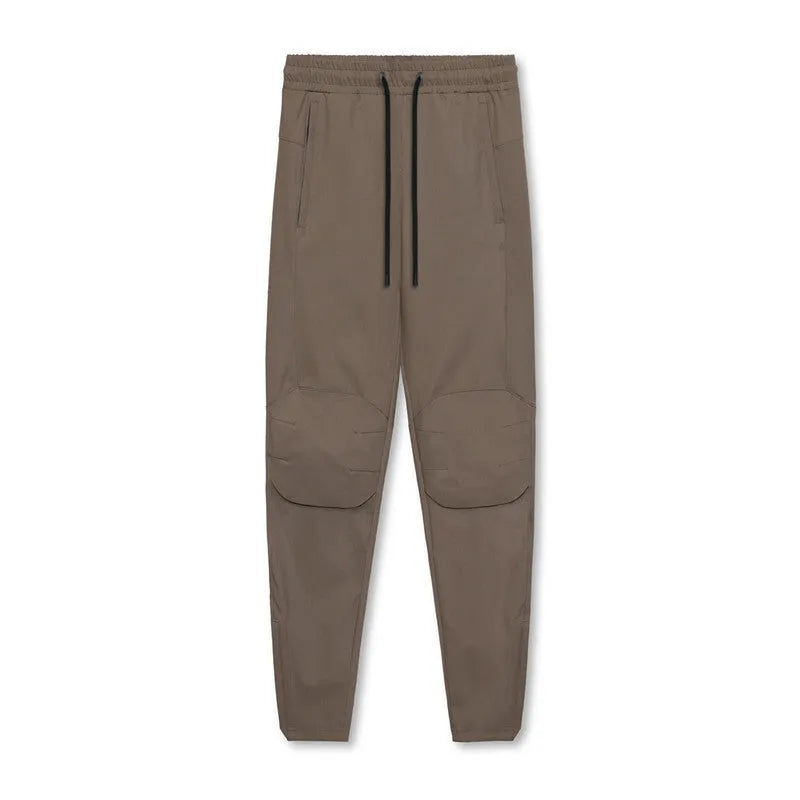 Men's loose fit quick-dry running pants with ankle ties in woodland camouflage and solid colours for gym fitness training.