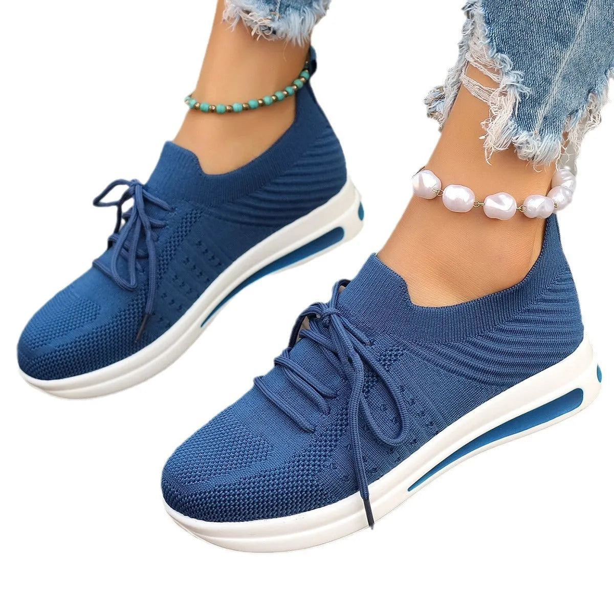 Women's low-top red fly-knit sneakers with round toe and lace-up front on a white background.