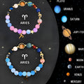 Set of two natural stone beaded bracelets with zodiac sign charms on a white background.