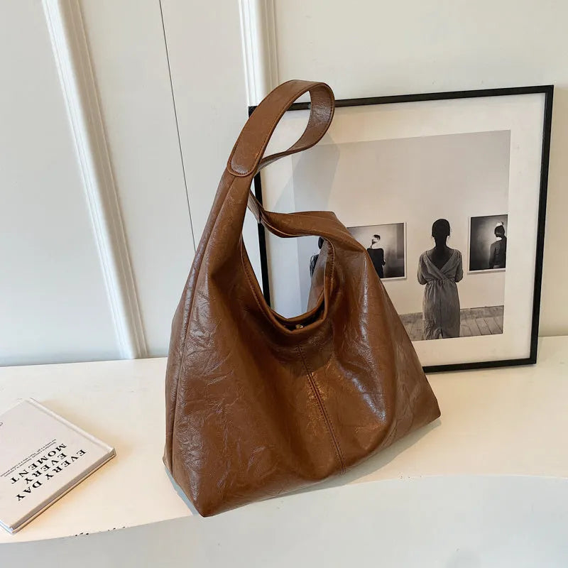 Soft leather shoulder bag in black with sandwich pocket design and shoulder strap