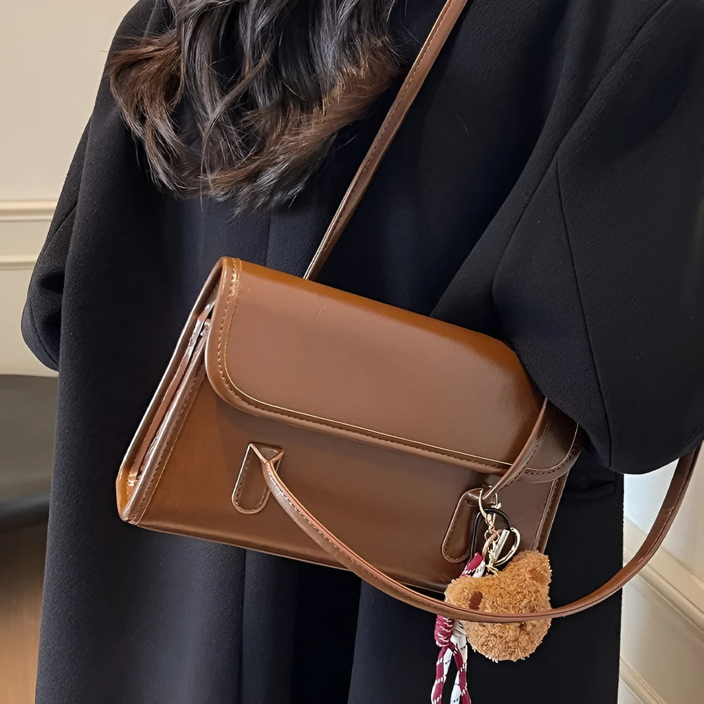 Women's brown PU leather square shoulder bag with pendant accessory showing interior zipper compartment