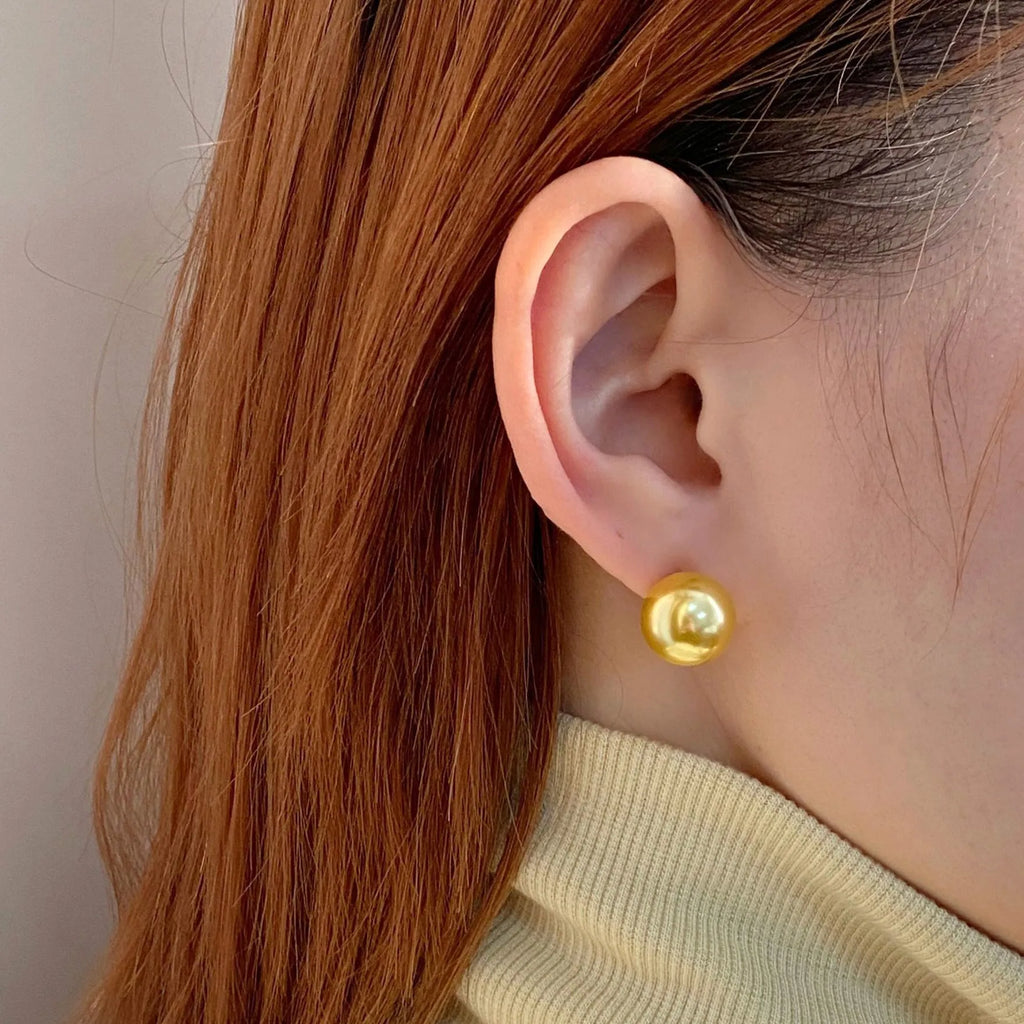 A pair of large geometric pearl stud earrings for women in silver, showing an eight-point star design detail.
