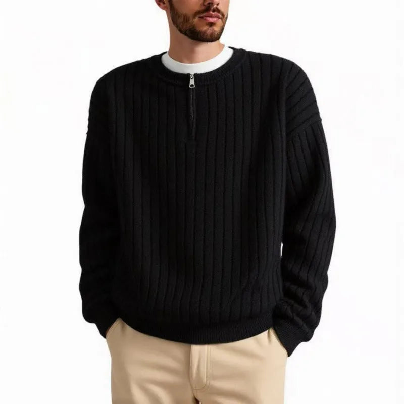 Man wearing a grey half-zip loose knit sweater, showing the textured fabric and front zip.
