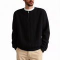Man wearing a grey half-zip loose knit sweater, showing the textured fabric and front zip.