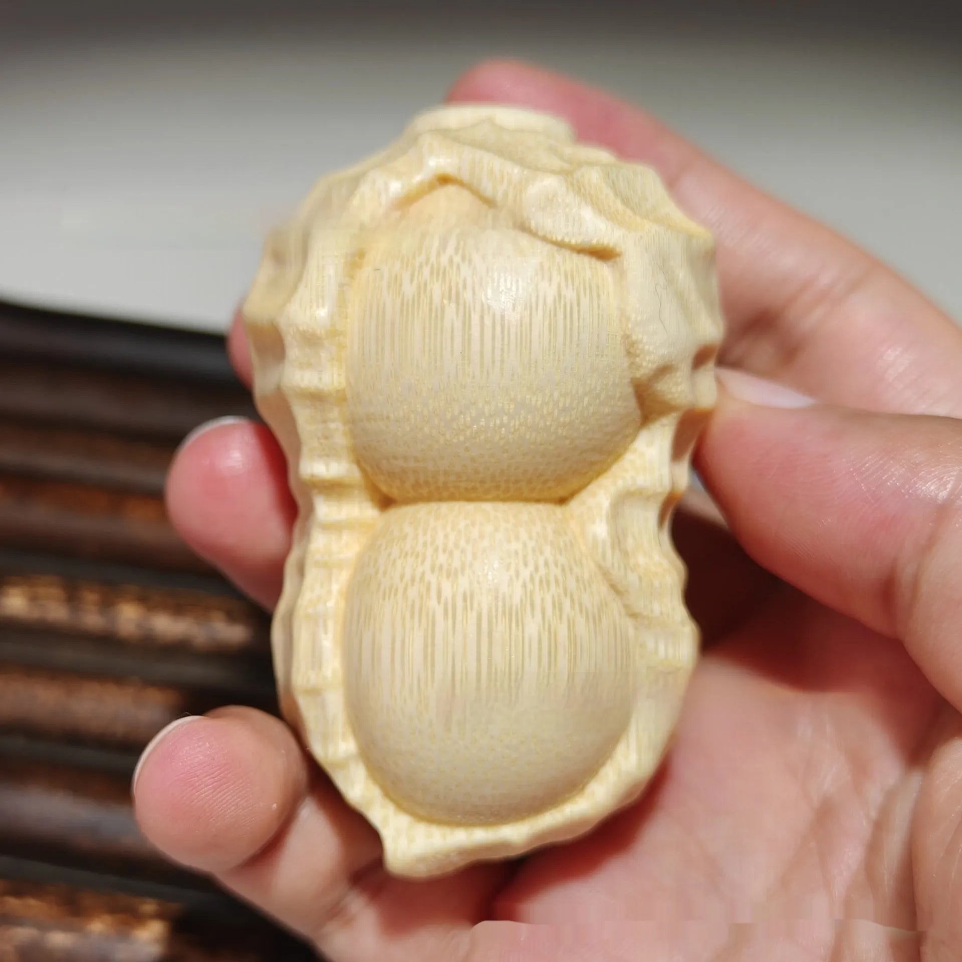 Carved solid bamboo peanut ornament in a modern simplicity style on a plain background.