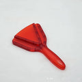 Red adjustable telescopic can opener and bottle opener with non-slip handle on a kitchen counter.