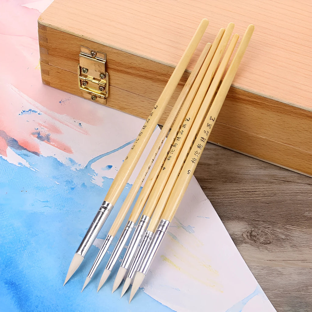 Six wooden pen brushes with pointed wool brush heads arranged as an artistic tool set