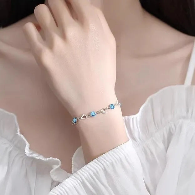 Blue diamond heart necklace and bracelet set with adjustable chain on display