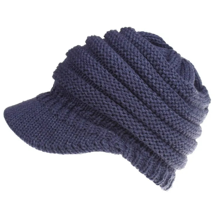 Women's acrylic knitted ponytail beanie hat in beige colour on a model.