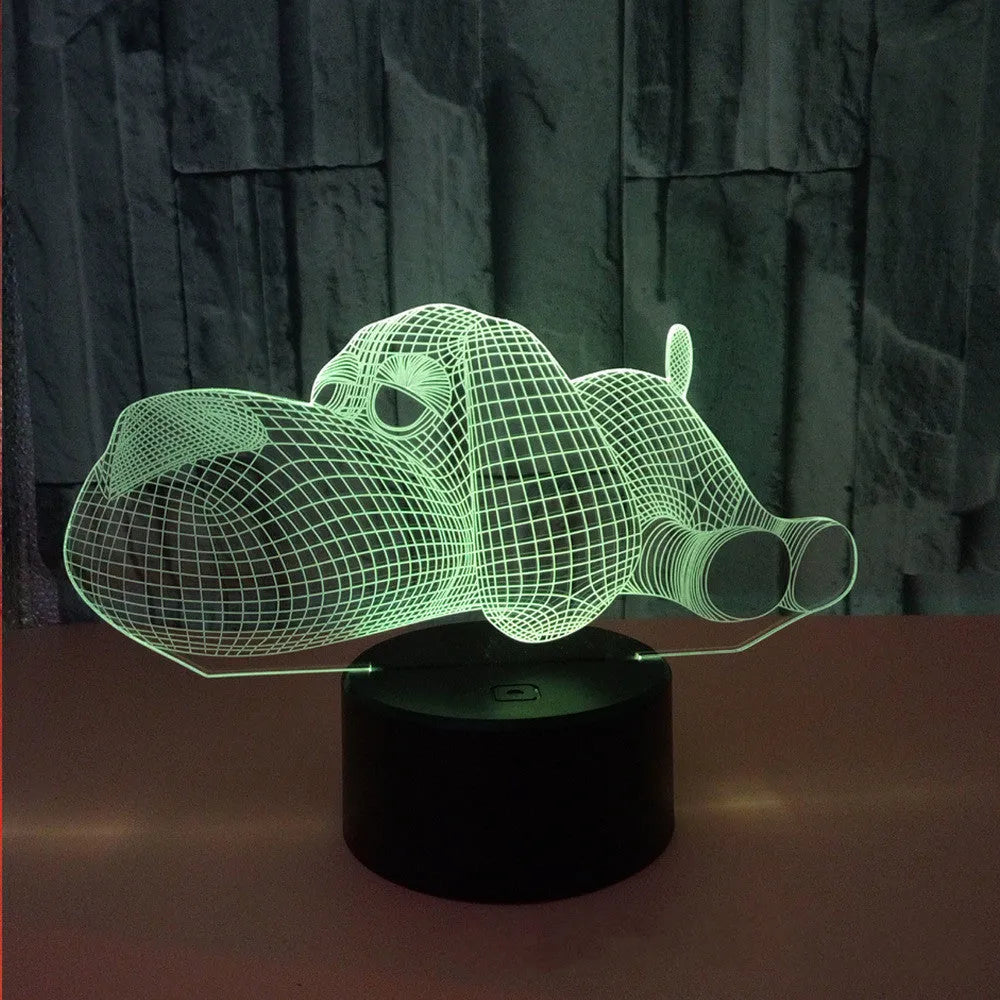 Dog-shaped 3D desktop lamp glowing in multiple colours on a wooden surface.