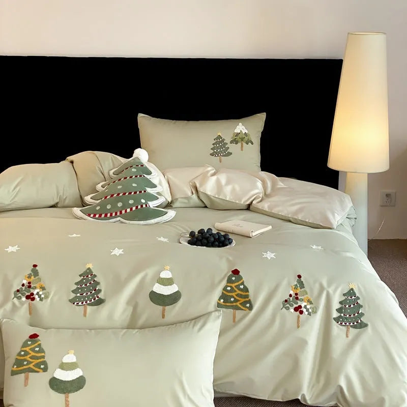 Four-piece cotton bedding set with Christmas tree towel embroidery pattern showing duvet cover, bed sheet, and pillowcases