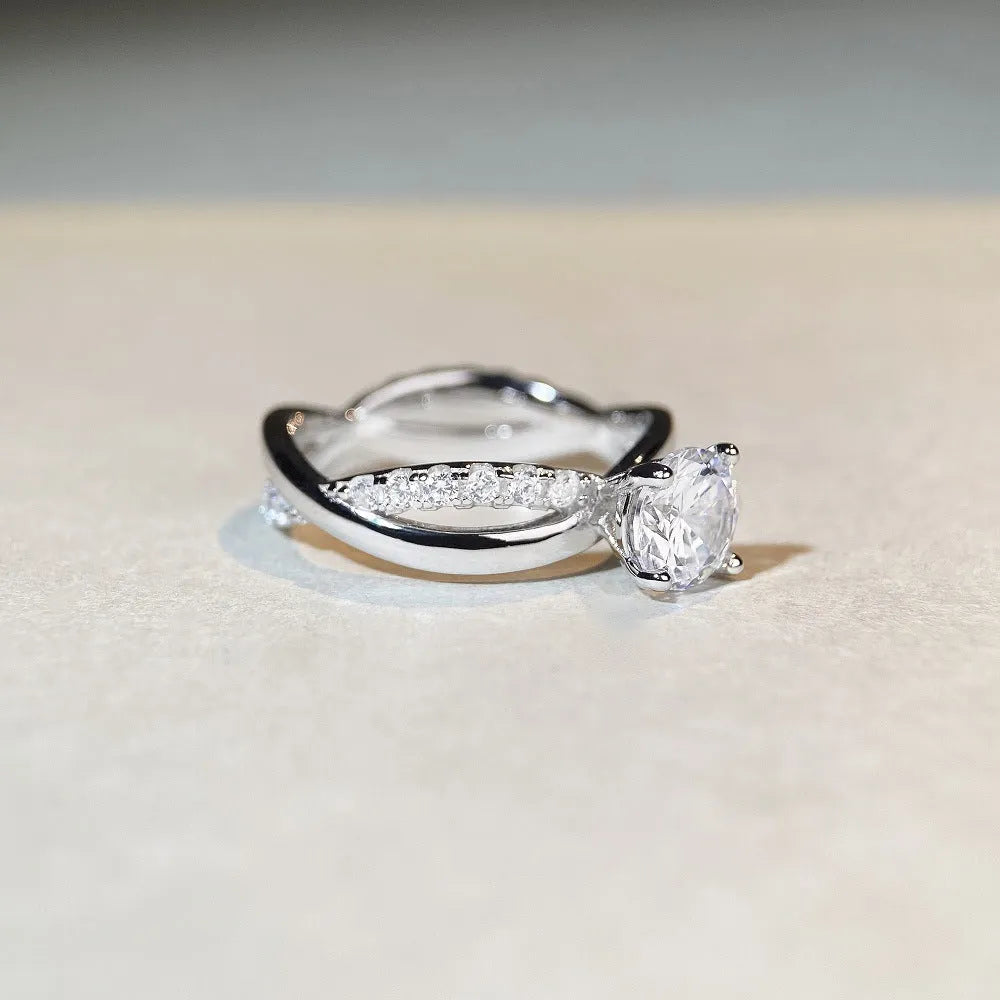 Silver moissanite ring with twisted arm band and four-claw setting holding 1 karat stone