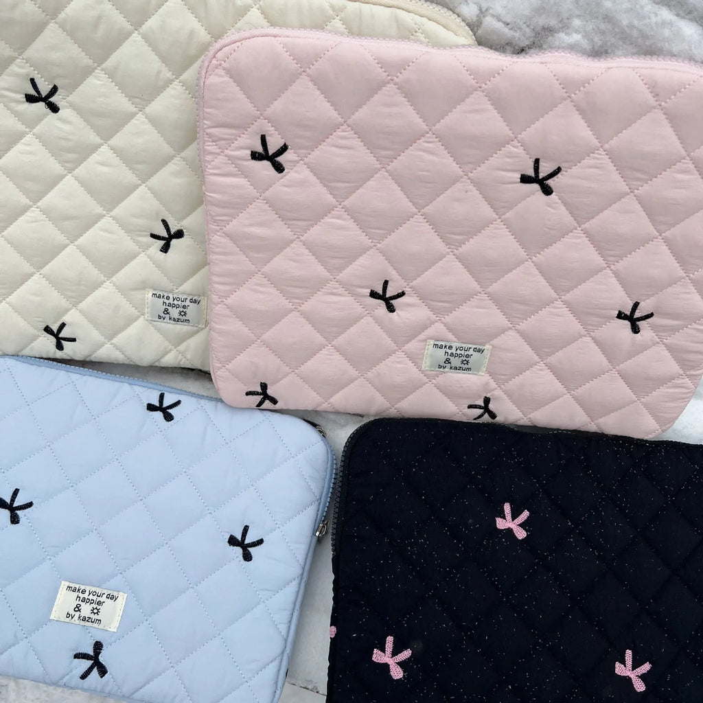 Cute white nylon laptop bag with a rhombus embroidered bow, shown next to a laptop.