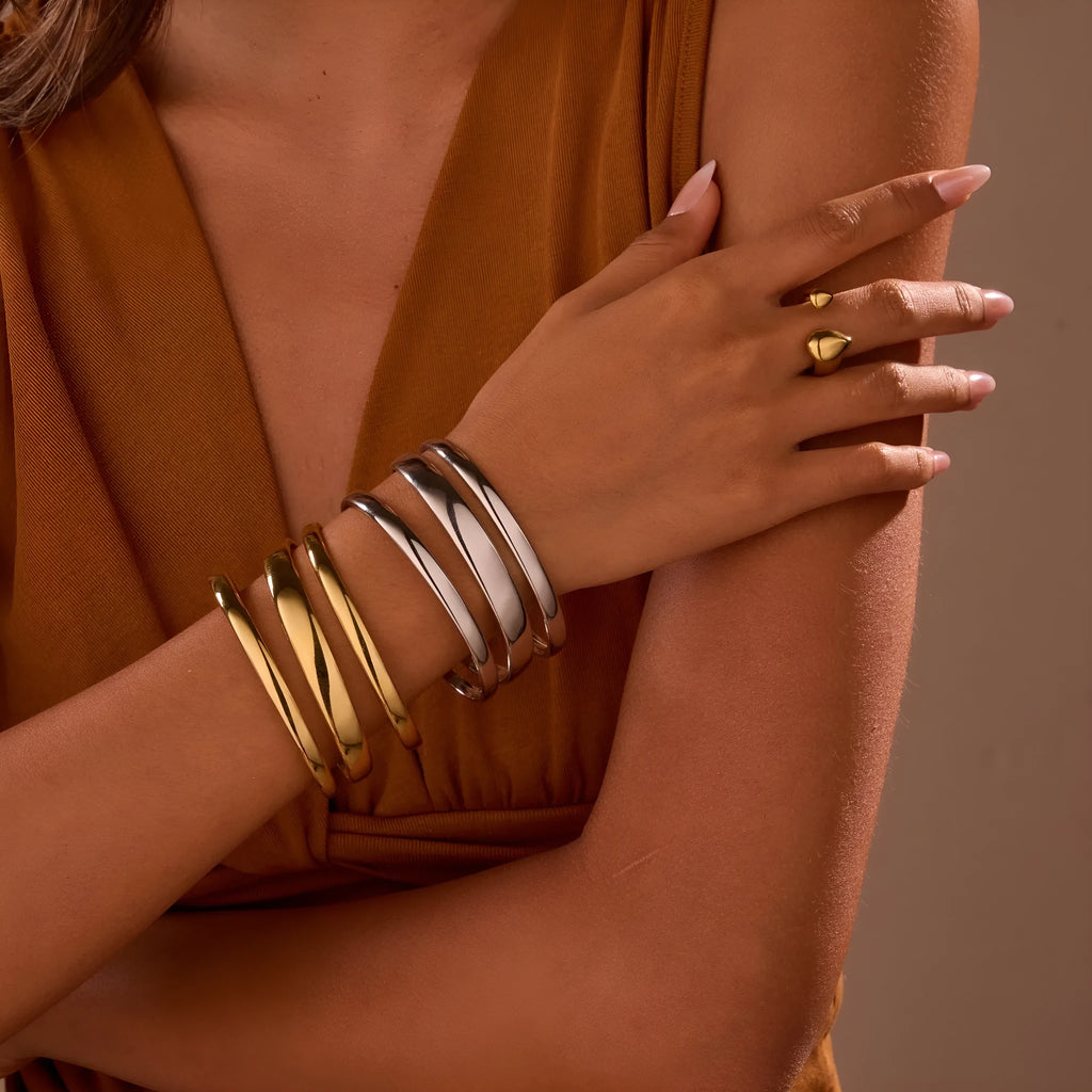 Geometric stainless steel women's bracelet with a simple opening mechanism, shown in gold and steel finish options.