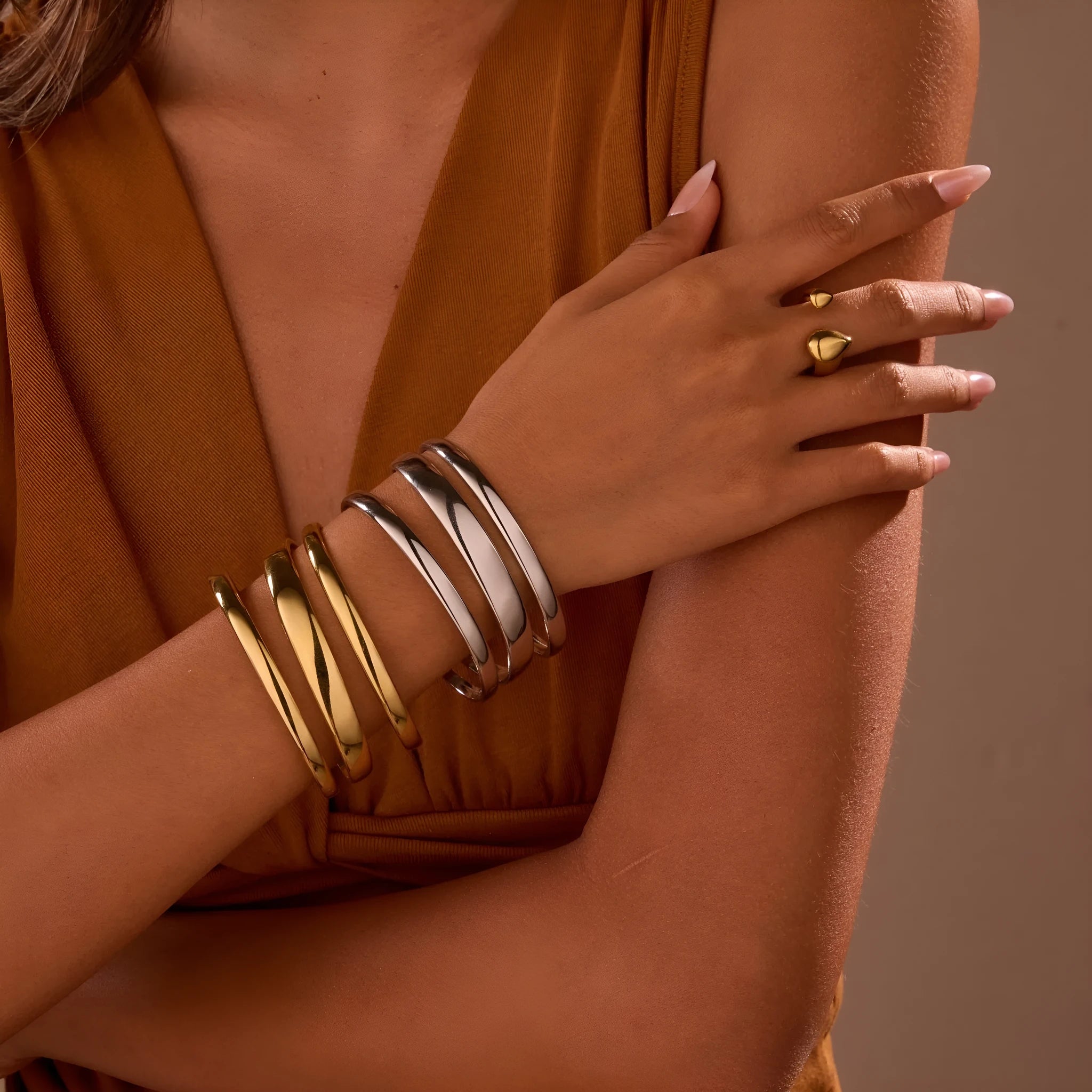 Geometric stainless steel women's bracelet with a simple opening mechanism, shown in gold and steel finish options.