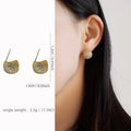 Geometric drop-shaped ear clips with full diamond detailing and sphere elements in gold and white colour options