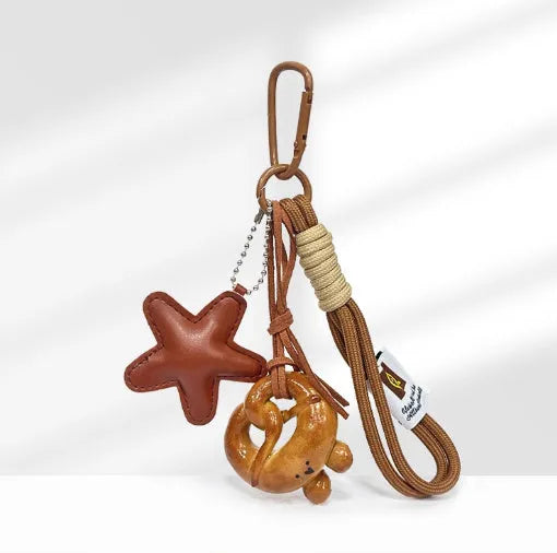Handmade brown polymer clay soda bread charm on a brown strap, showing cartoon bread design details.