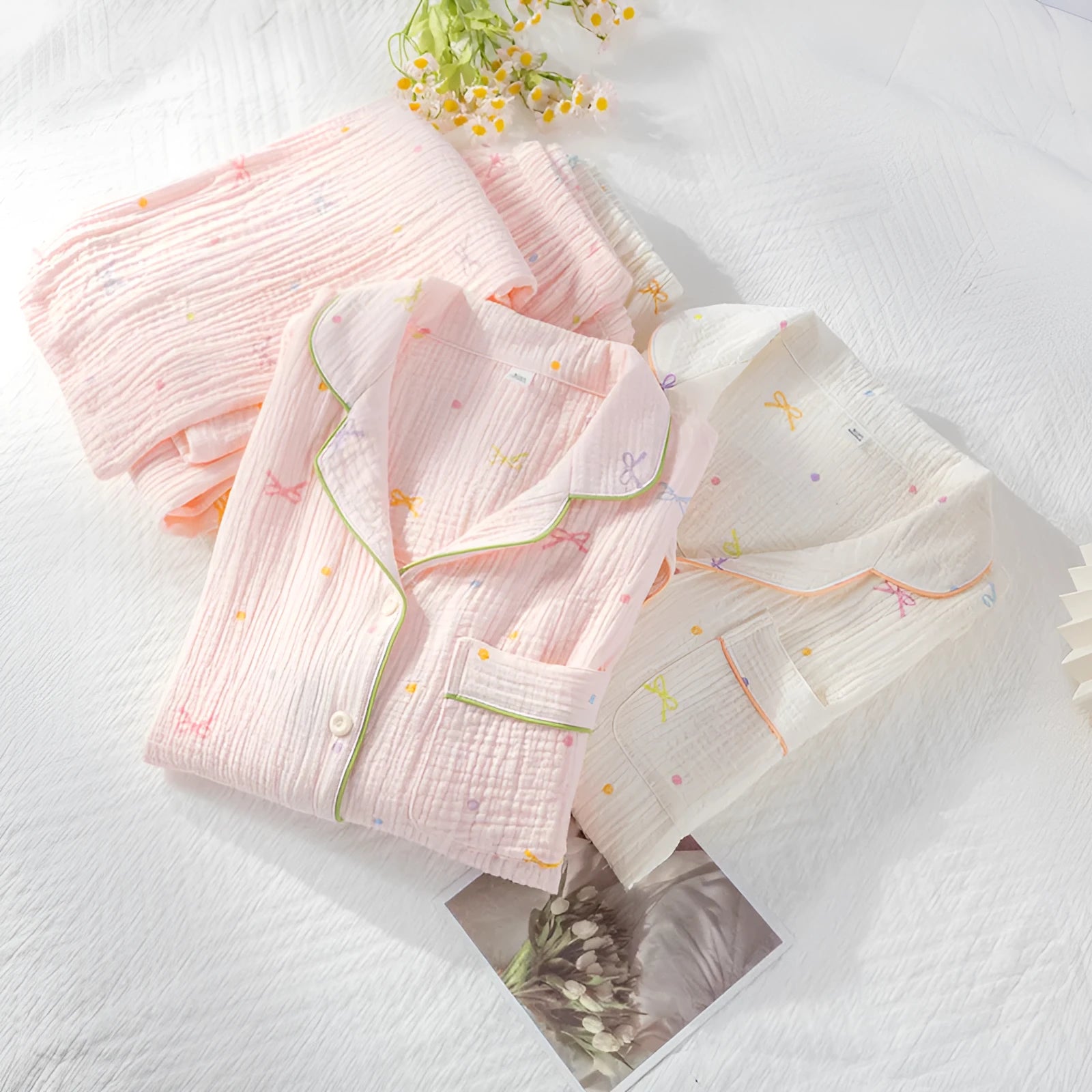Women's beige long sleeve cotton pajama top and trousers set laid flat.