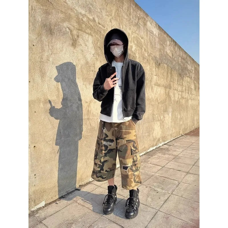 Men's camouflage cropped jeans with patchwork detailing and distressed rips in loose straight-leg fit