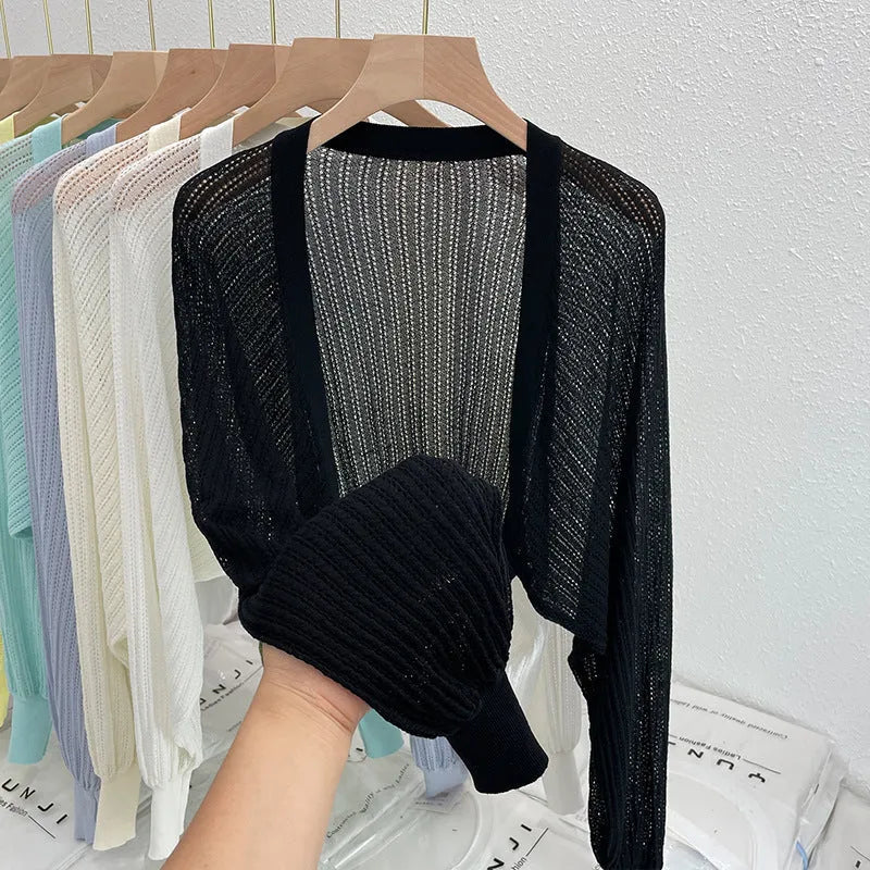 Thin loose linen blouse with hollow out lantern sleeves in apricot colour on a hanger.