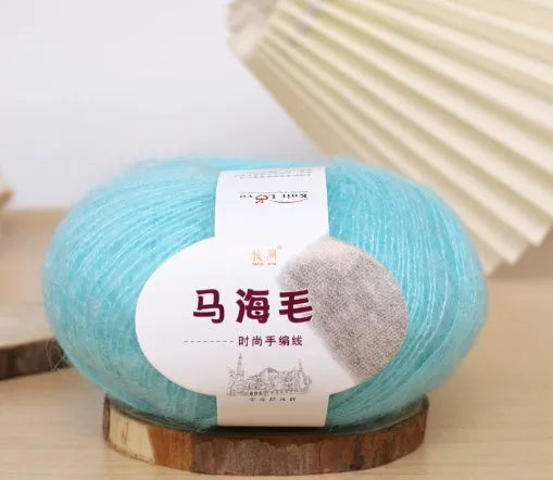 DIY mohair scarf weaving kit showing one wool ball and a selection of 34 colour options including white, pink, blue and green.