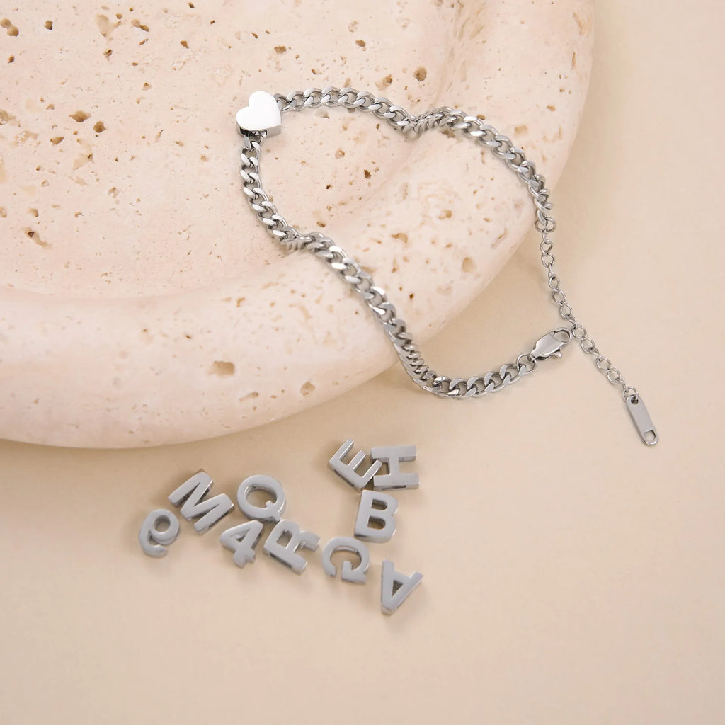 Gold and silver titanium steel necklaces showing letter A and number 7 pendants on 40.5cm chains.